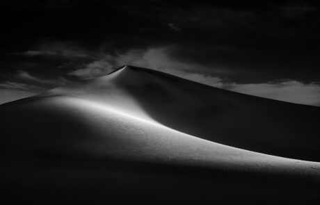 Black and white artistic photograph of sand dunes in Death Valley National Park.