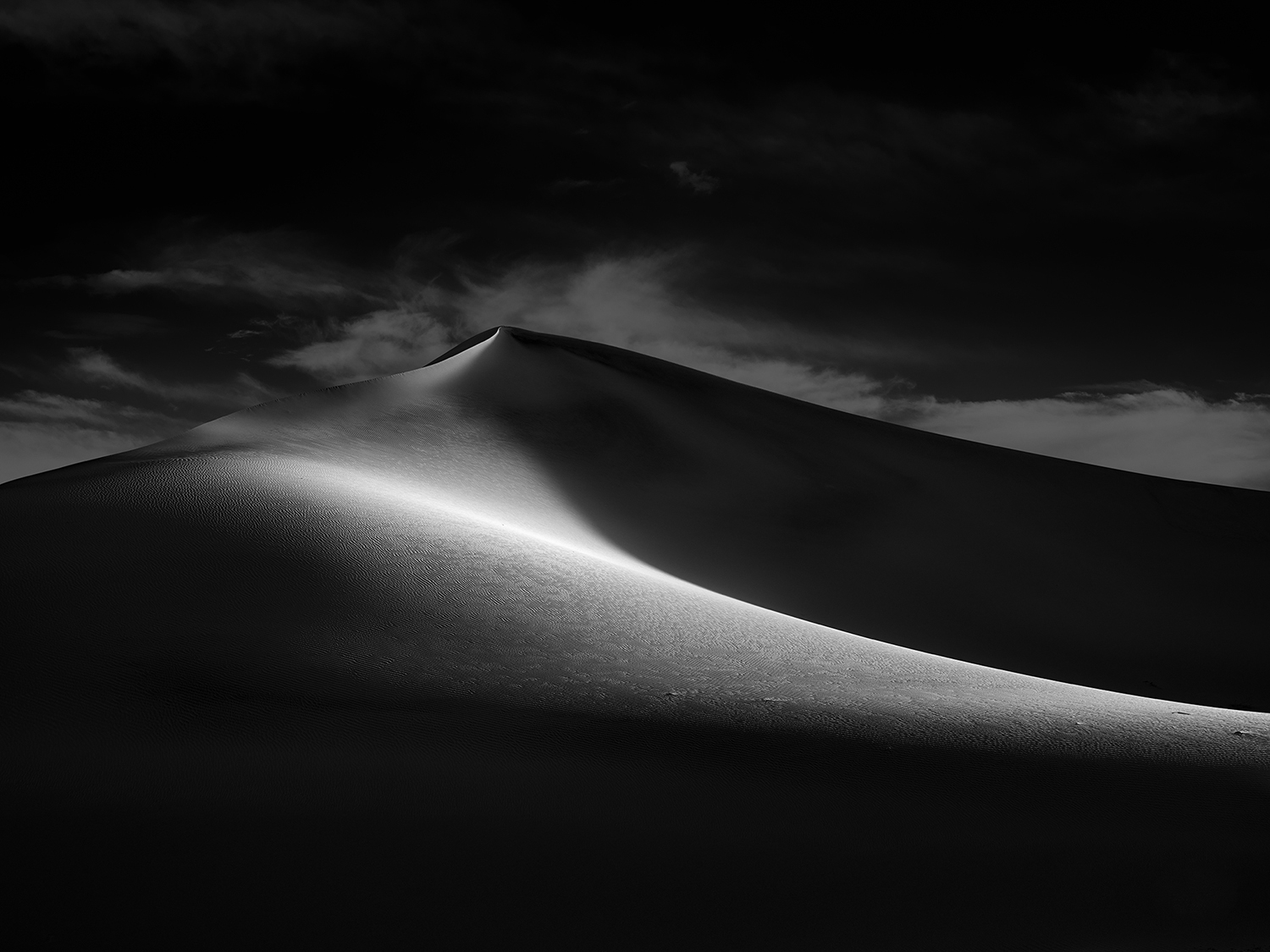 Black and white artistic photograph of sand dunes in Death Valley National Park.