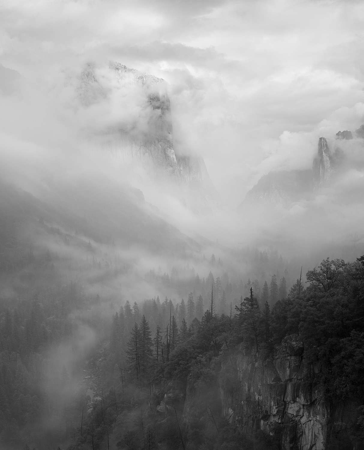 Black and white fine art photograph of a foggy morning in Yosemite National Park from Tunnel view in Yosemite Valley.